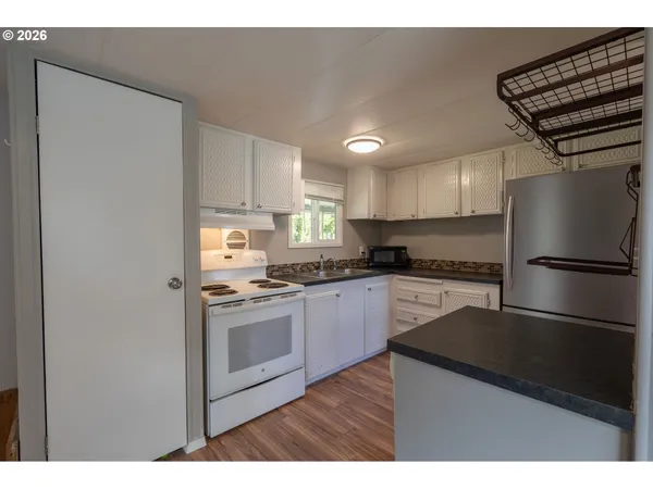 a kitchen with a refrigerator and a stove top oven