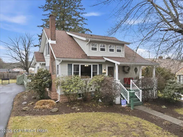 a view of a house with a yard and potted plants