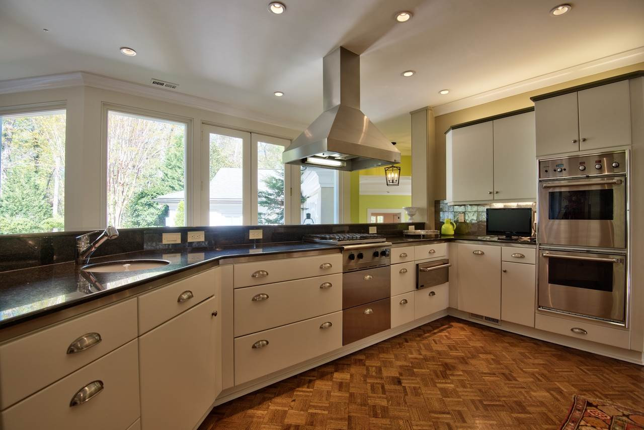 3114 Devon Road Durham, NC 27707 - Photo 11 of 25 a large kitchen with stainless steel appliances granite countertop a stove a sink and a microwave
