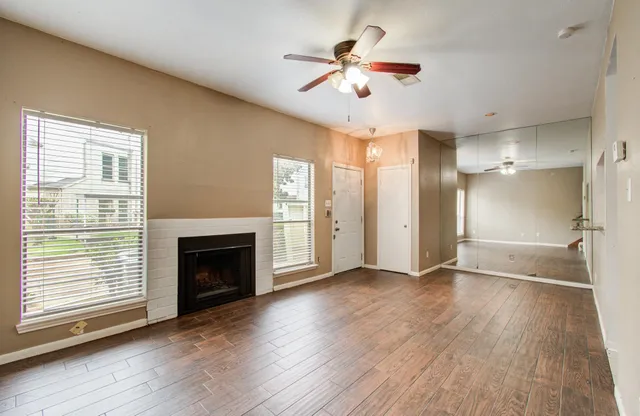a view of an empty room with a fireplace and a window
