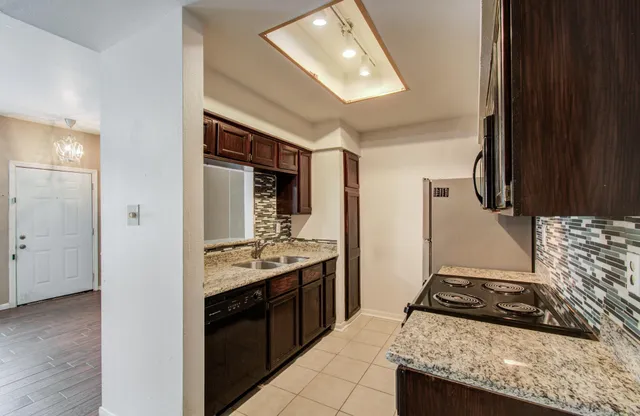 a kitchen with stainless steel appliances granite countertop a stove and a sink