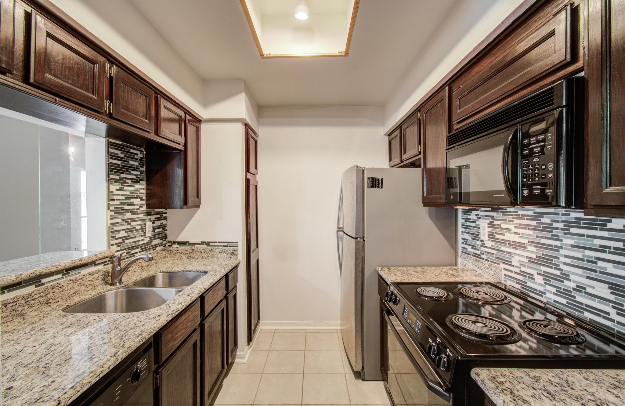 8299 Cambridge Street, Unit 1706 Houston, TX 77054 - Photo 9 of 26 a kitchen with stainless steel appliances granite countertop a sink stove and refrigerator