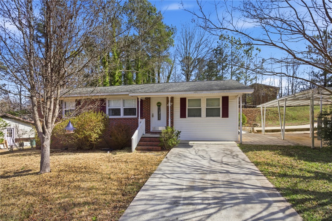 A well-maintained single-story home with a tidy front yard and a convenient carport.