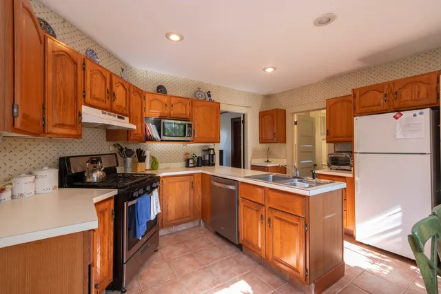 a kitchen with stainless steel appliances granite countertop a stove a sink dishwasher and a refrigerator