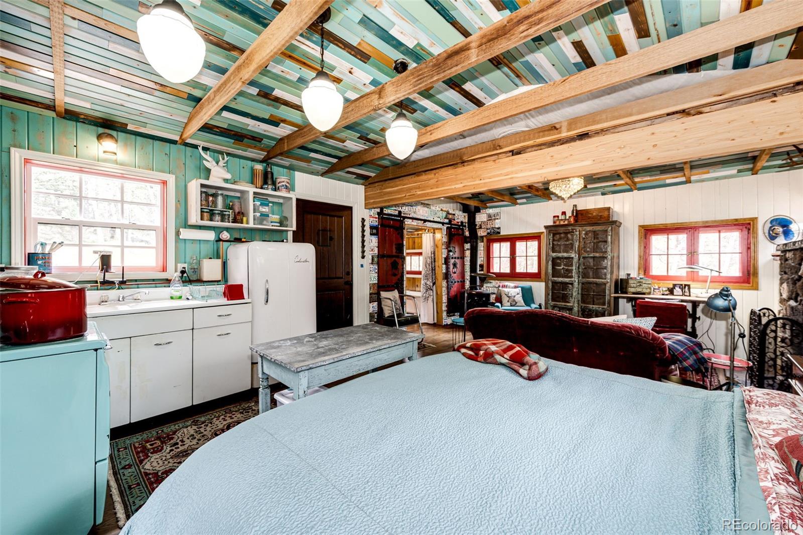 12346 Bear Haven Road Conifer, CO 80433 - Photo 37 of 47 a bed room with furniture and a chandelier