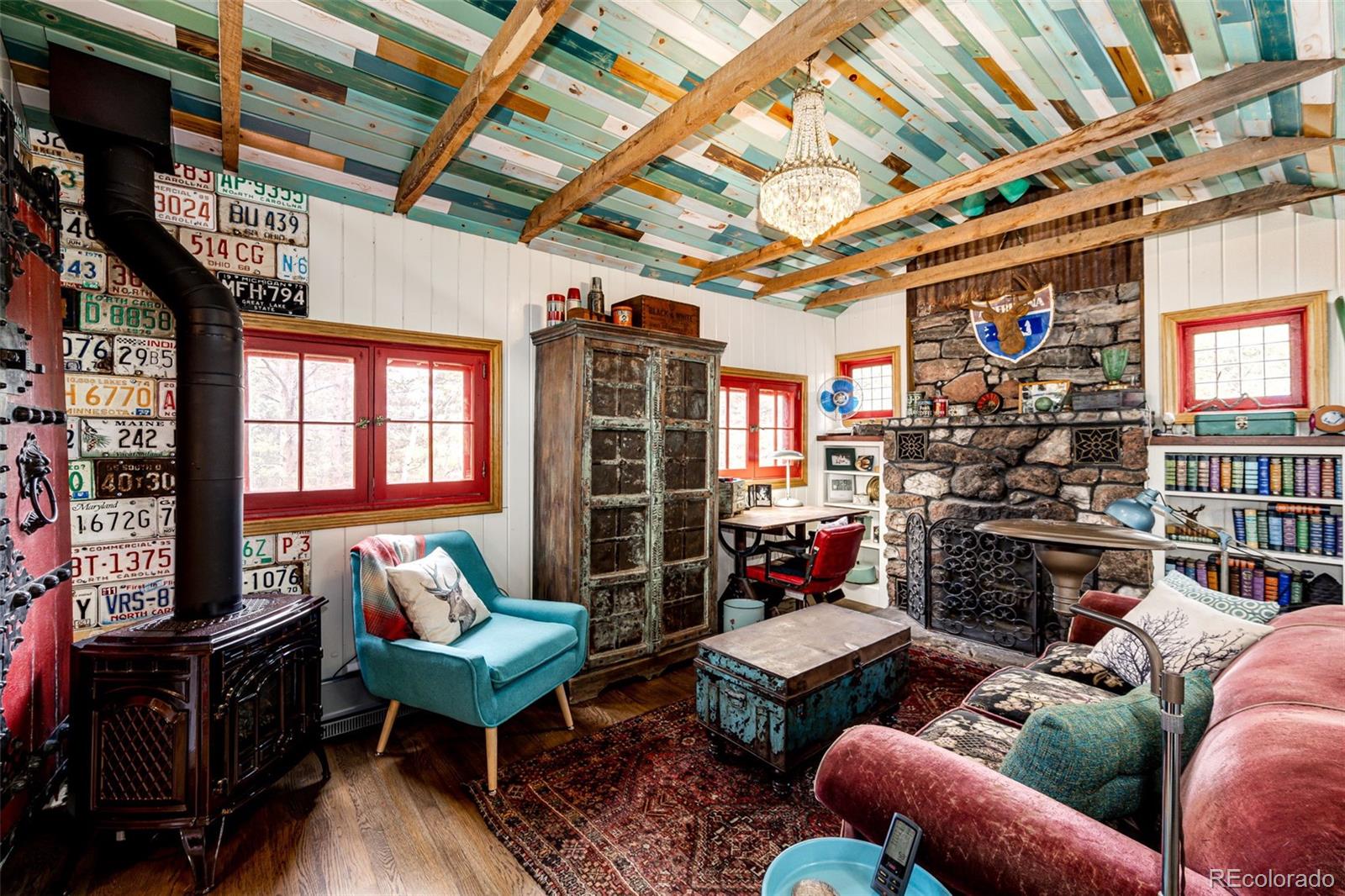 12346 Bear Haven Road Conifer, CO 80433 - Photo 38 of 47 a living room with furniture a fireplace and a flat screen tv