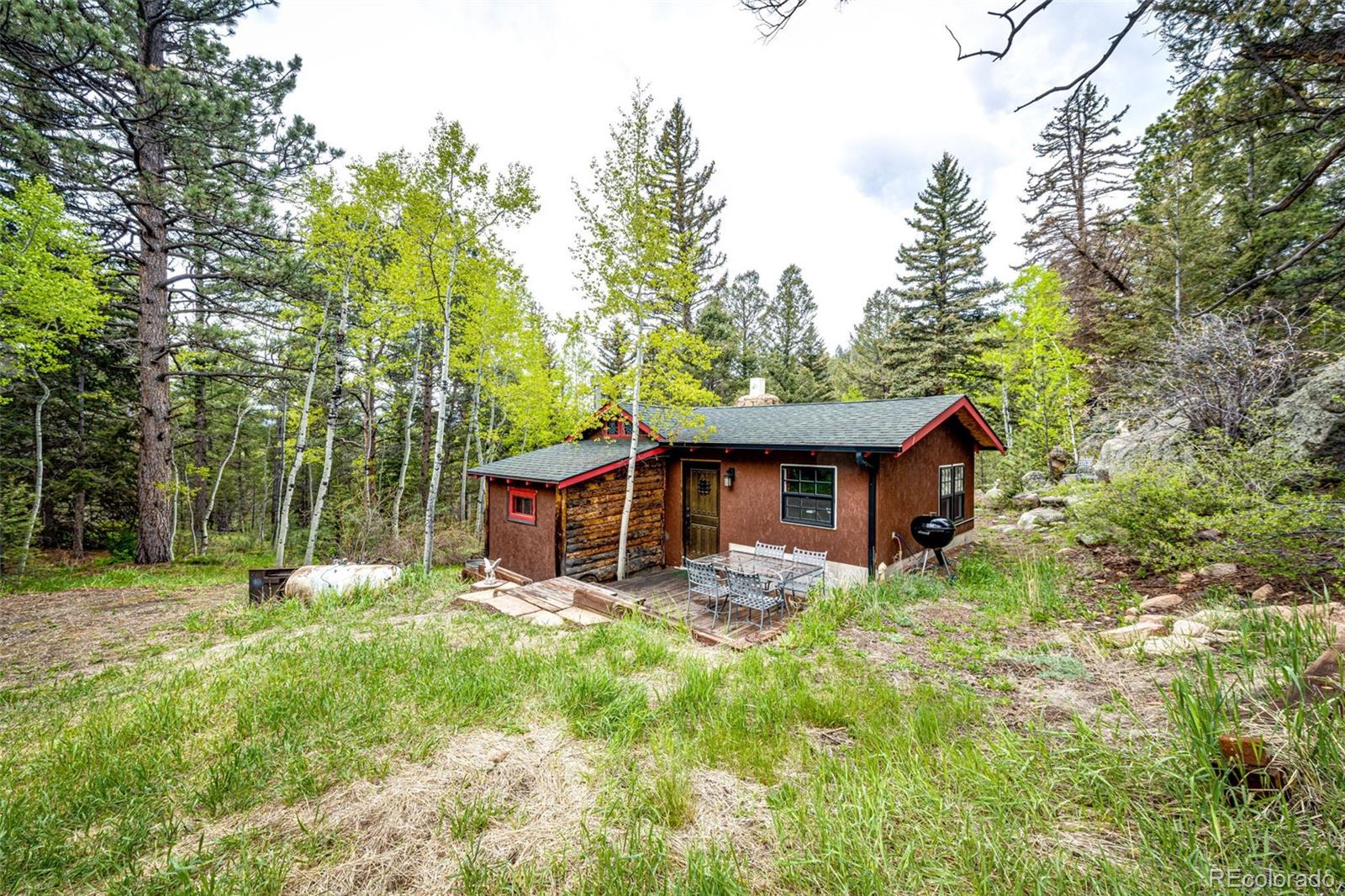 12346 Bear Haven Road Conifer, CO 80433 - Photo 40 of 47 a view of a wooden house with a big yard and large trees
