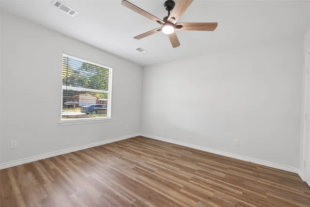wooden floor in an empty room with a window