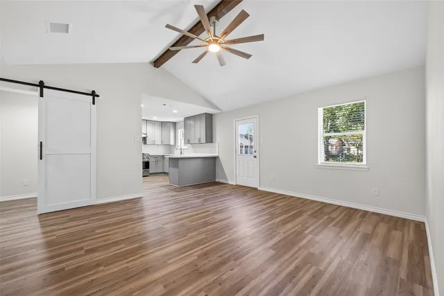 a view of empty room with wooden floor and ceiling fan