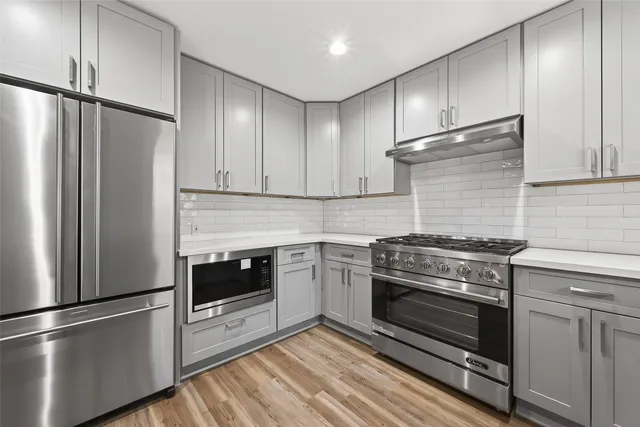 a kitchen with granite countertop stainless steel appliances and wooden cabinets