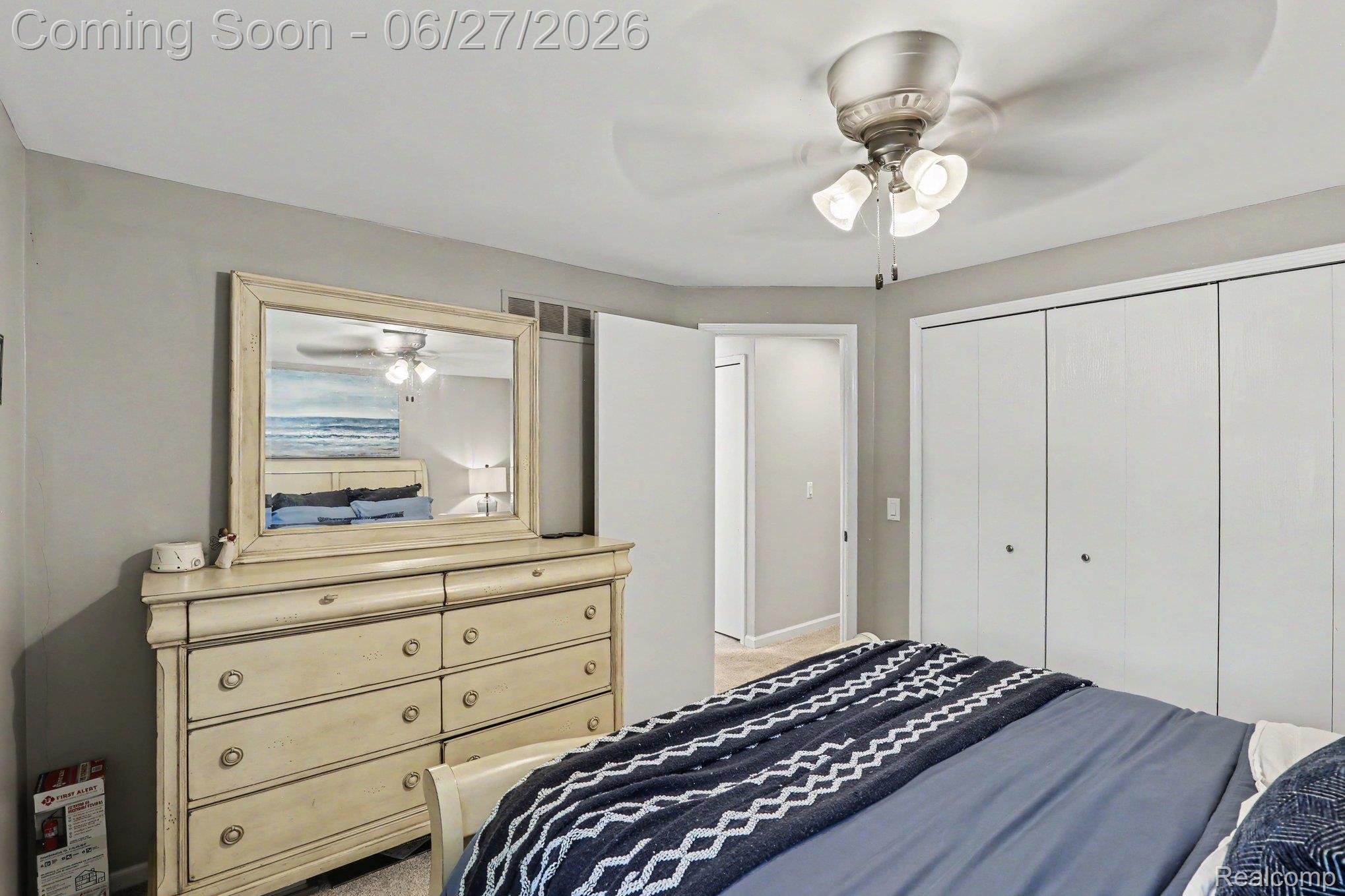 5134 Old Cove Road Clarkston, MI 48346 - Photo 19 of 27 Bedroom featuring light gray walls, plush carpeting, a multi-paneled closet with white bi-fold doors, and a ceiling fan with integrated lighting