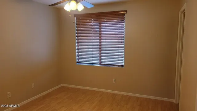 an empty room with windows and fan