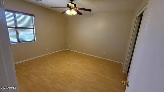 an empty room with closet and a chandelier fan