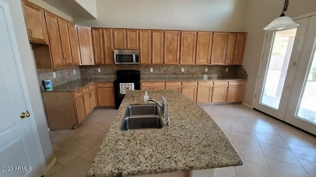 a kitchen with a sink a stove and cabinets