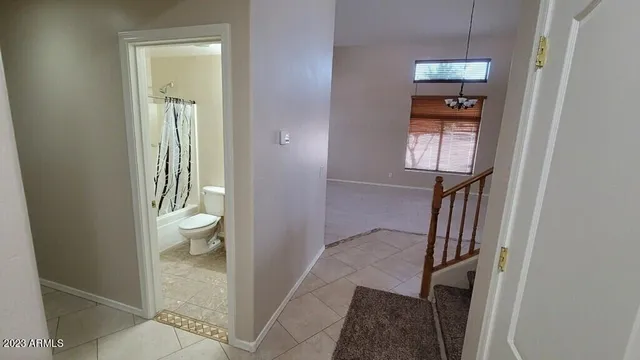 a view of a hallway with wooden floor and a bathroom