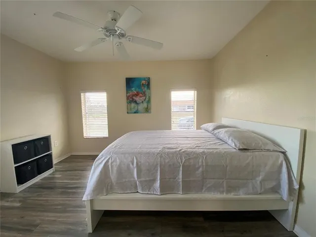 a bedroom with a bed and a ceiling fan