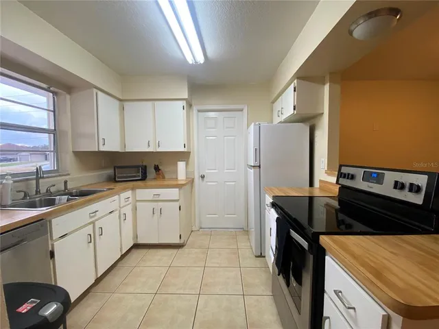 a kitchen with a sink stove and refrigerator