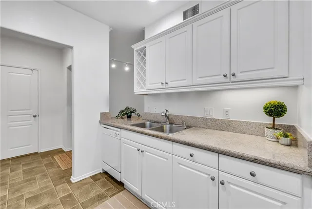 a kitchen with stainless steel appliances white cabinets and a stove top oven