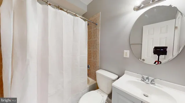 a bathroom with a sink mirror and toilet