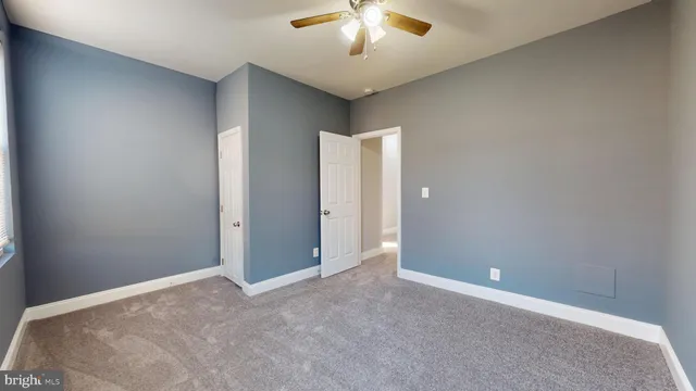 a view of an empty room with a chandelier fan