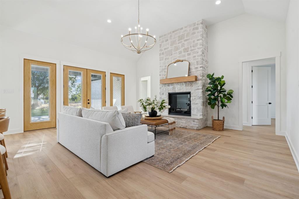 8008 Ben Day Murrin Road Fort Worth, TX 76126 - Photo 5 of 40 a living room with furniture a fireplace and a chandelier