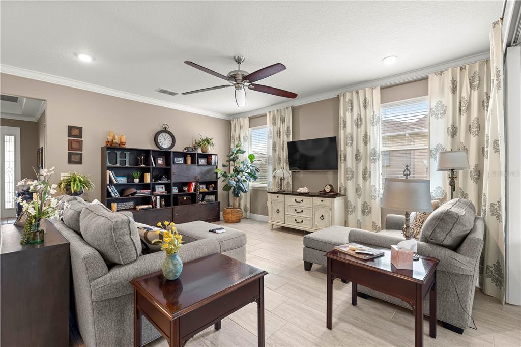 9099 Southwest 89th Loop Ocala, FL 34481 - Photo 11 of 66 a living room with furniture a flat screen tv and a large window