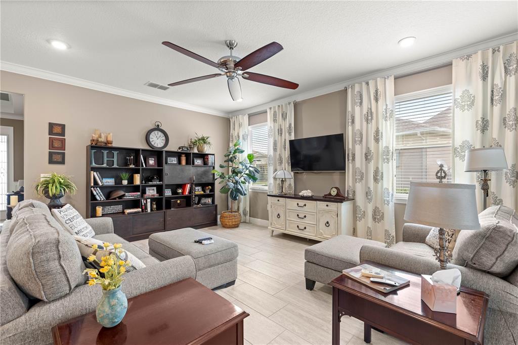 9099 Southwest 89th Loop Ocala, FL 34481 - Photo 12 of 66 a living room with furniture and a flat screen tv