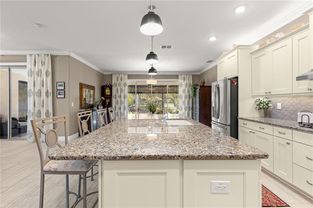9099 Southwest 89th Loop Ocala, FL 34481 - Photo 15 of 66 a kitchen with granite countertop kitchen island stainless steel appliances a sink and a refrigerator
