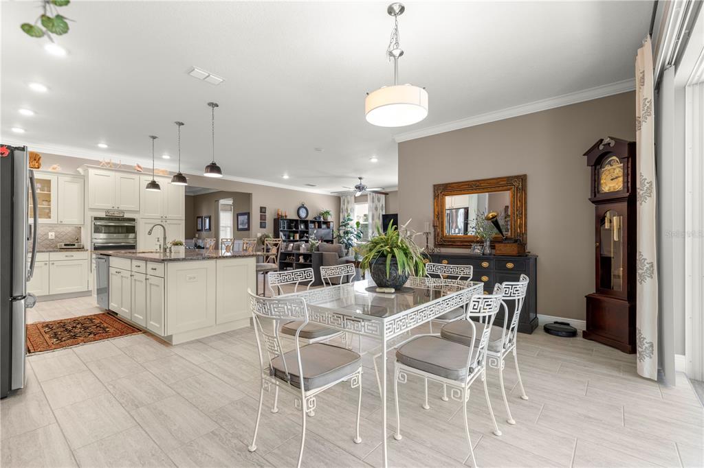 9099 Southwest 89th Loop Ocala, FL 34481 - Photo 21 of 66 a kitchen with stainless steel appliances kitchen island granite countertop a dining table chairs and white cabinets