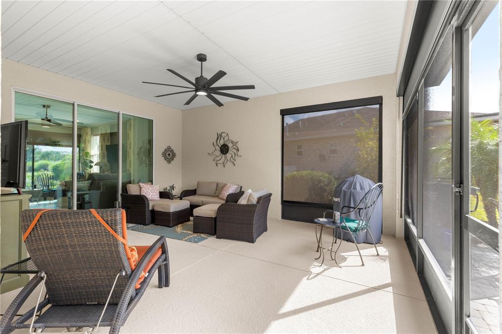 9099 Southwest 89th Loop Ocala, FL 34481 - Photo 51 of 66 a living room with furniture a ceiling fan and a large window