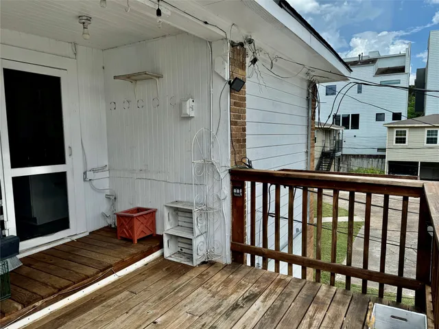 a view of a balcony with wooden floor and chair
