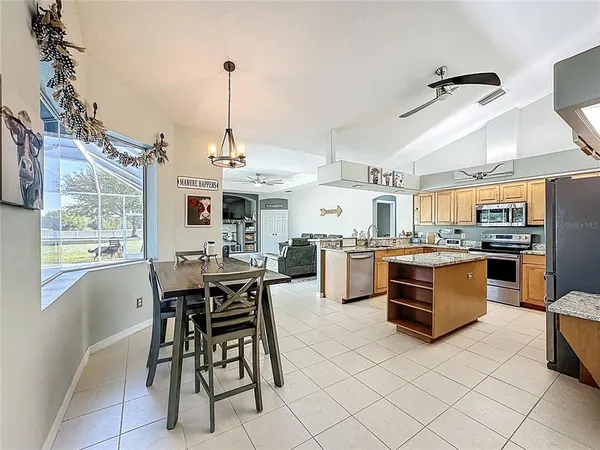 a kitchen with stainless steel appliances kitchen island granite countertop a stove and a refrigerator
