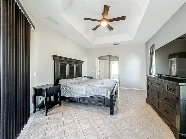a bedroom with a bed a desk and chair with window
