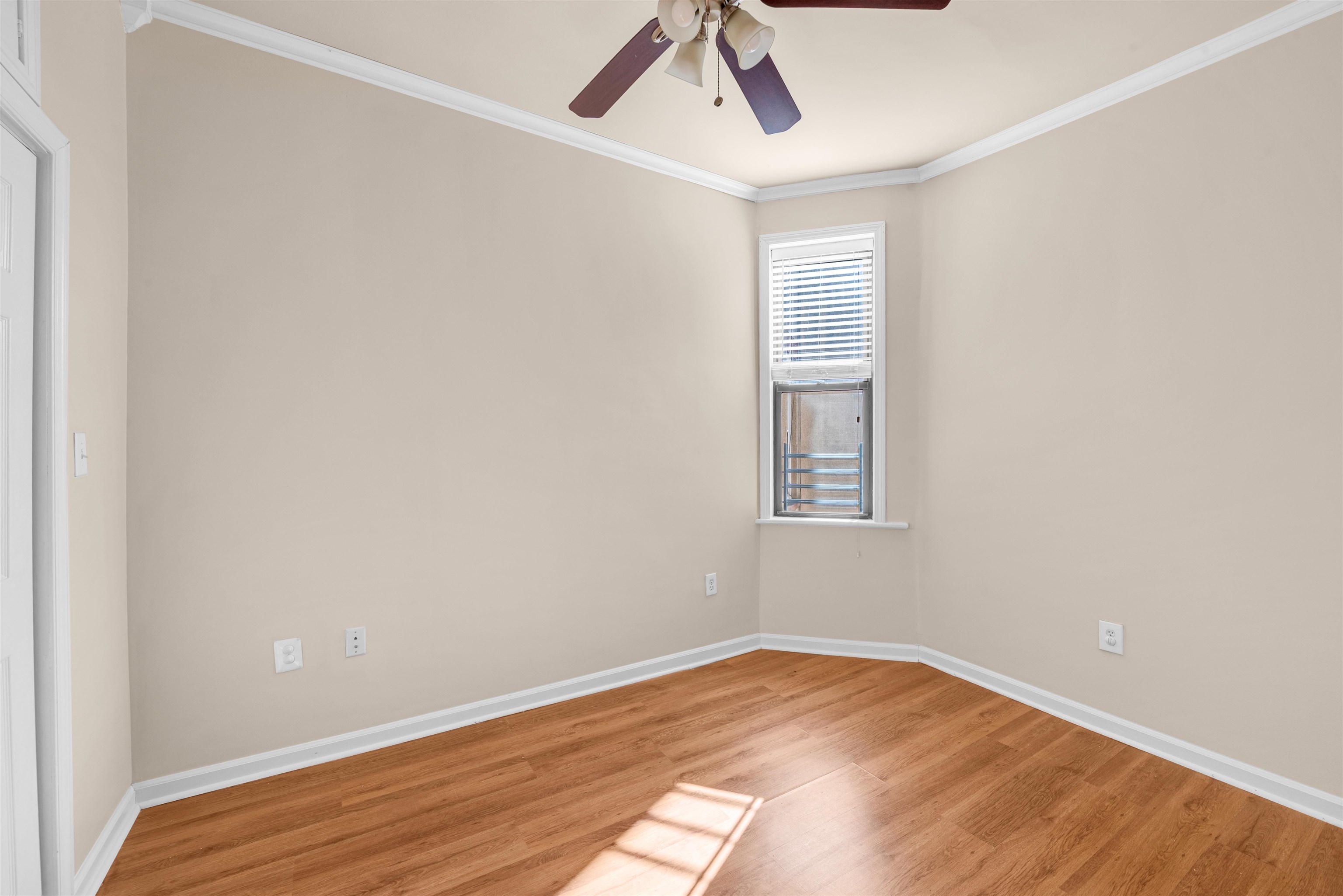 312 Monastery Place, Unit 3R Union City, NJ 07087 - Photo 8 of 16 an empty room with wooden floor chandelier fan and windows