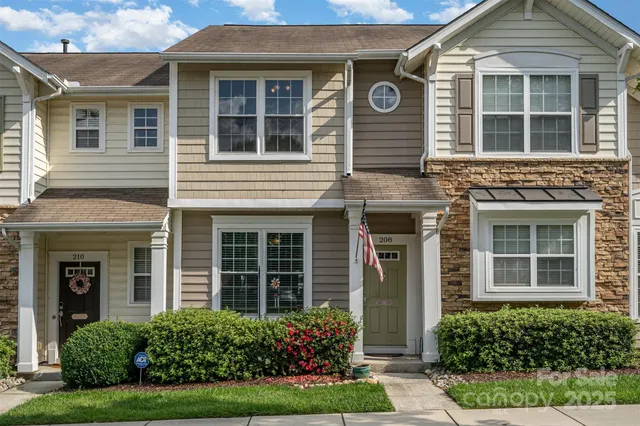 a view of a brick house with a large windows and plants