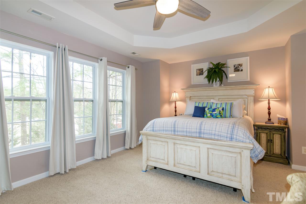 8630 Redcrest Place Raleigh, NC 27617 - Photo 11 of 24 a bedroom with a bed a table and painting on the wall