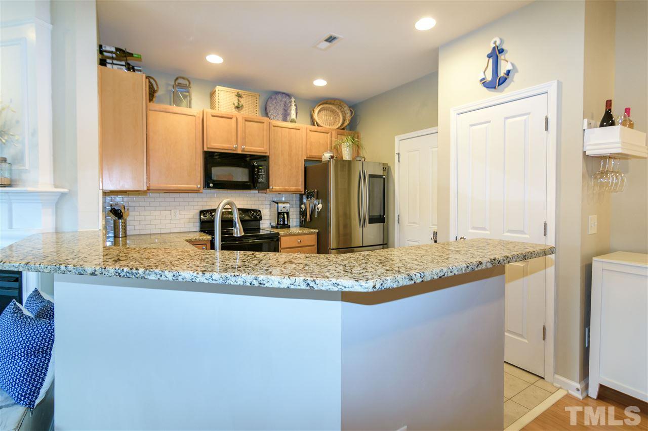 8630 Redcrest Place Raleigh, NC 27617 - Photo 4 of 24 a kitchen with stainless steel appliances granite countertop a sink a stove a refrigerator a microwave and island