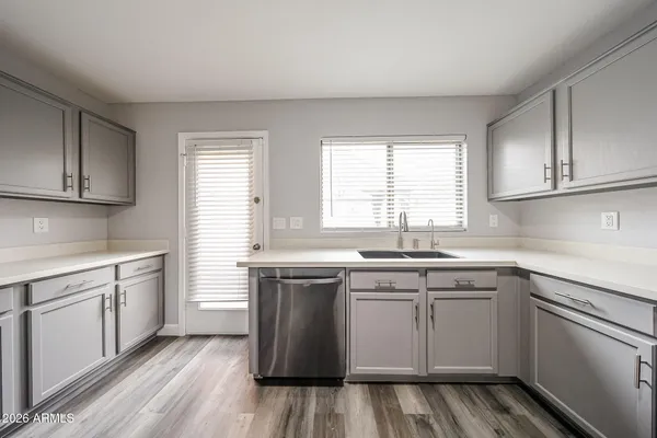 a kitchen with a sink stove cabinets and wooden floor