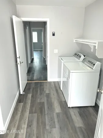 a view of a hallway with wooden floor and washer