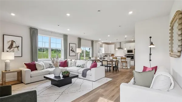 a living room with furniture kitchen view and a potted plant