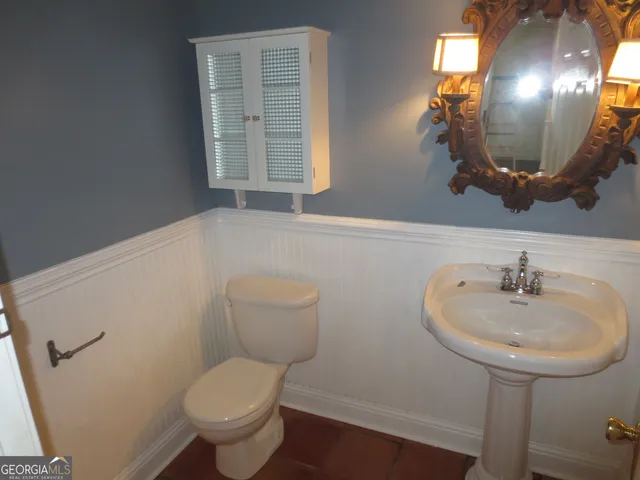 a bathroom with a sink a toilet and mirror