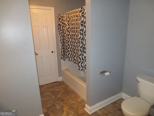 a bathroom with a toilet and a shower