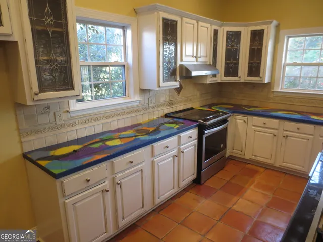 a kitchen with stainless steel appliances granite countertop a sink stove and cabinets