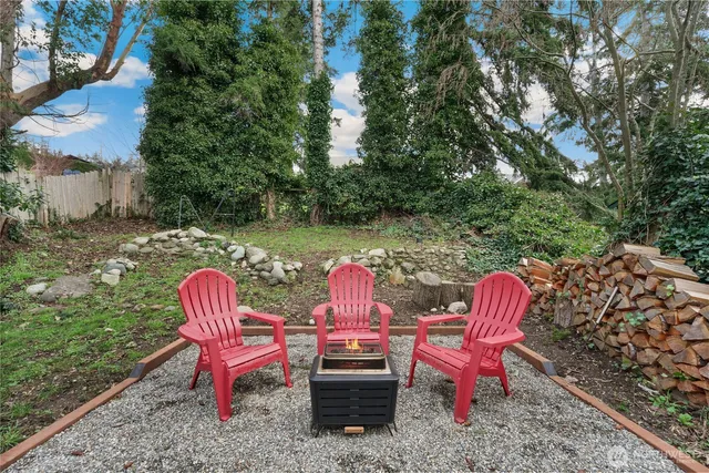a view of a wooden chairs and fire pit in the backyard