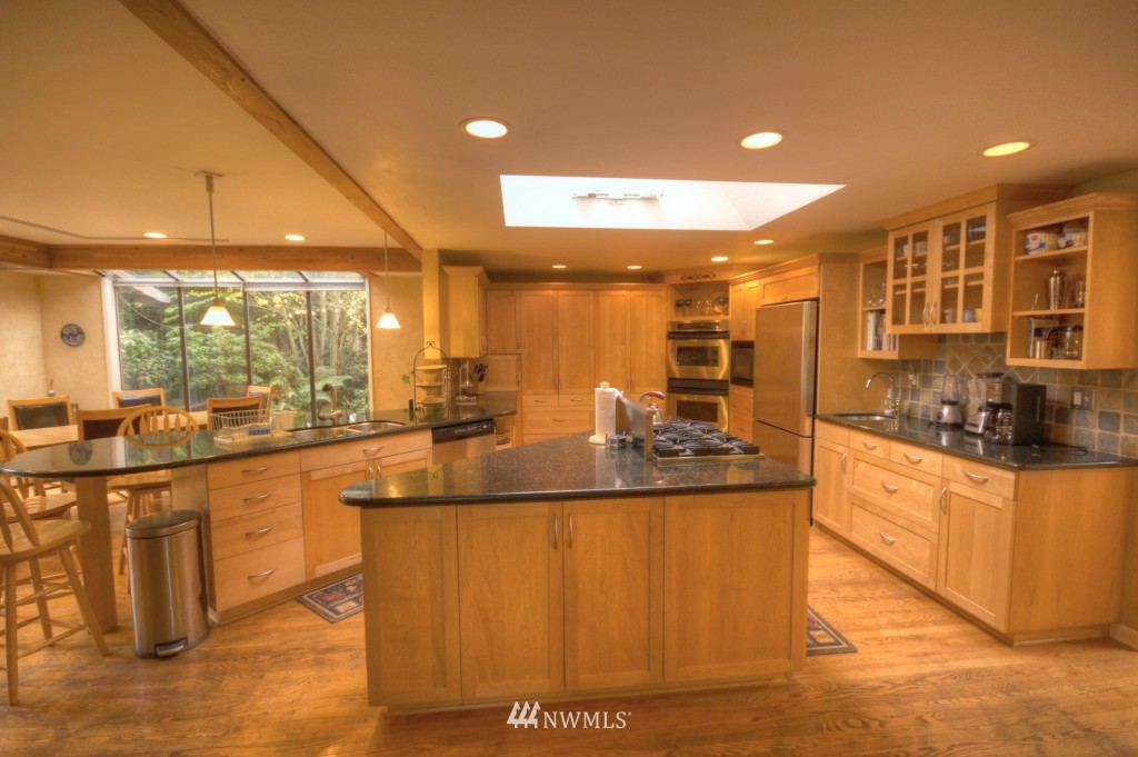 509 Bayside Road Bellingham, WA 98225 - Photo 3 of 17 a large kitchen with kitchen island a sink a counter top space and stainless steel appliances