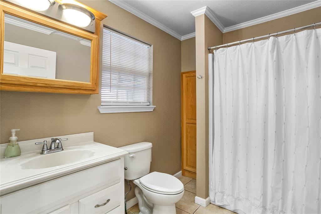 1825 North Highland Avenue Sherman, TX 75092 - Photo 23 of 38 a bathroom with a sink a toilet and a mirror