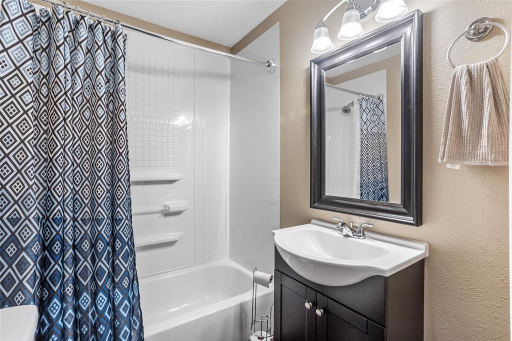 1825 North Highland Avenue Sherman, TX 75092 - Photo 27 of 38 a bathroom with a sink a mirror and a bathtub