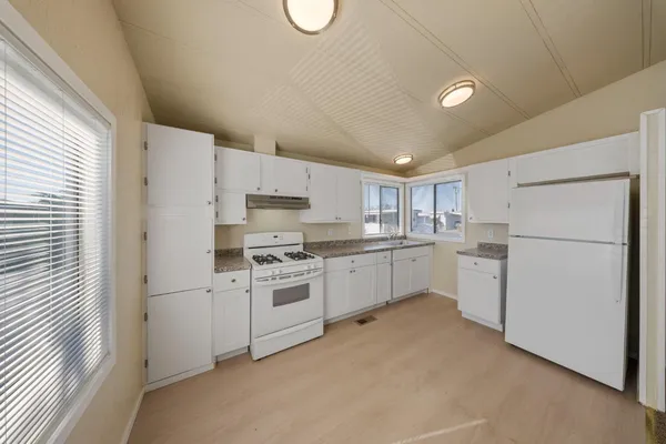 a kitchen with white cabinets and white appliances