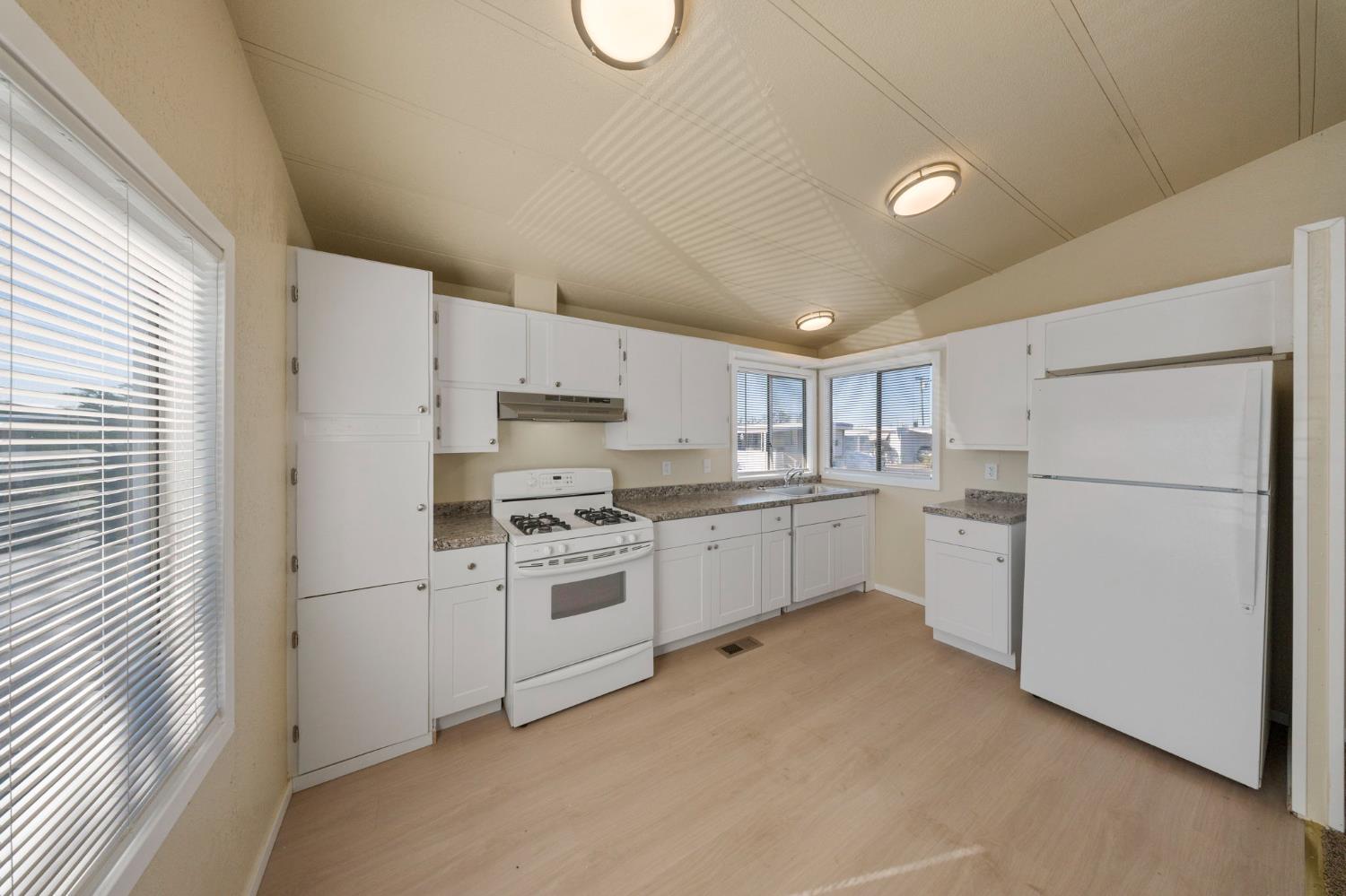 3550 Mitchell Road, Unit 59 Ceres, CA 95307 - Photo 13 of 18 a kitchen with white cabinets and white appliances