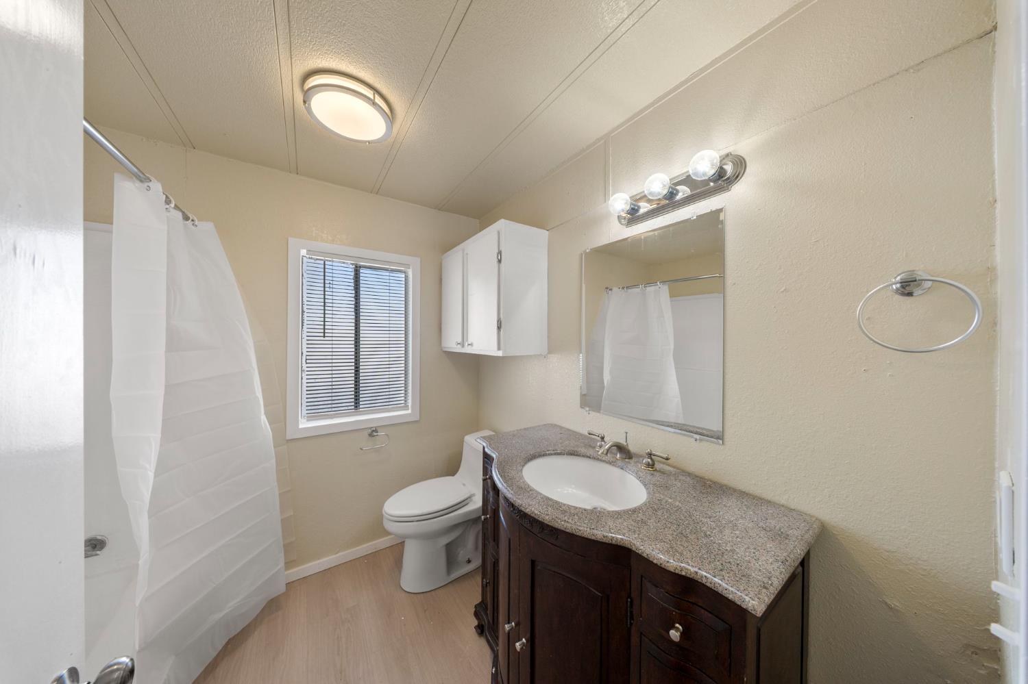 3550 Mitchell Road, Unit 59 Ceres, CA 95307 - Photo 14 of 18 a bathroom with a granite countertop sink toilet and mirror